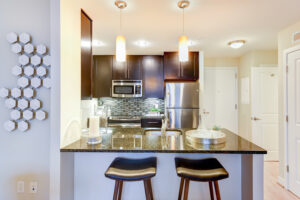 large kitchen with bright lighting, breakfast bar, brown cabinets, and stainless steel appliances