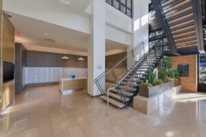 Interior Lobby, contemporary decor, stairwell left of entrance, cluster mailbox unit in lobby, metal planter boxes.
