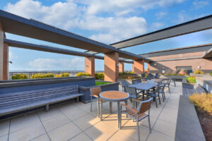 Outdoor rooftop dining area, bushes planted along dining tables.